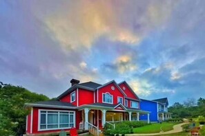 A two-story house with a red and blue exterior, a front porch, and a driveway. - Yangzhou Rundfel Manor (Yizheng)