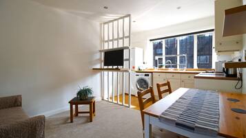 A compact living space with a kitchenette, a dining area, and a seating area.