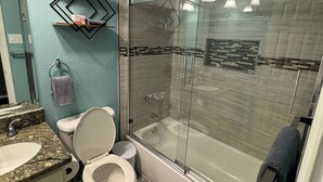Une salle de bain comprenant des toilettes, un lavabo et une baignoire.