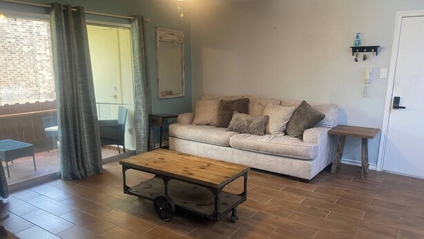 Un salon comprenant un canapé, une table basse, une petite table et une porte dotée d’un porte-clés.