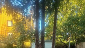 A backyard with a tree, a playhouse, and a table with chairs. - Annies Light Antique House (Mellerud)