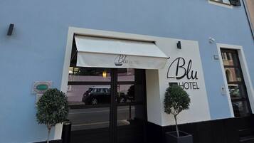 Ein zweistöckiges Hotel mit einem Schild, auf dem „Blu Hotel“ steht.