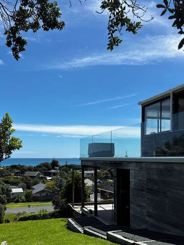 Cosy bach, fabulous views, a few minutes walk to beautiful surf beach, and Cafe.