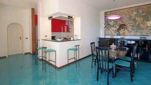 Eine moderne Küche mit Kochinsel, Barhocker und Esstisch mit Stühlen.