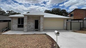 A single-story house with a garage, a front door, and a mailbox.