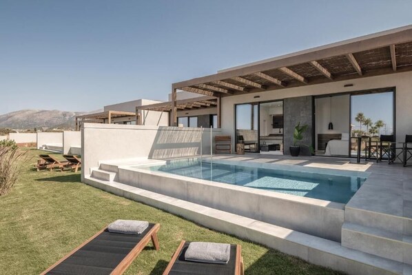 A modern outdoor pool area with a clear view of the mountains in the background. - Aku Suites with private pools (Malia)