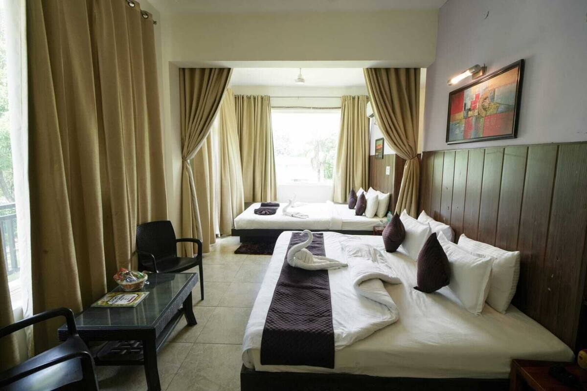 Ein Hotelzimmer mit zwei Betten, einem Schreibtisch und einem Stuhl.
