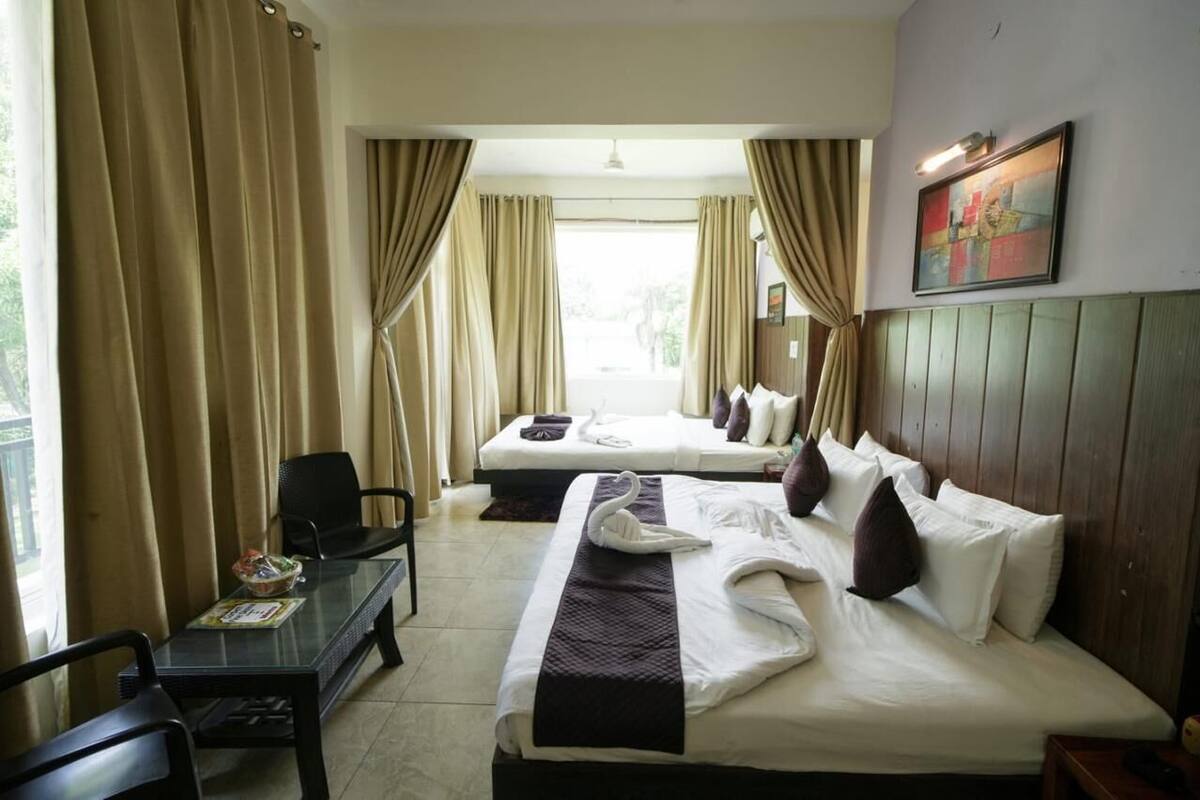 Ein Hotelzimmer mit zwei Betten, einem Schreibtisch und Blick ins Freie.