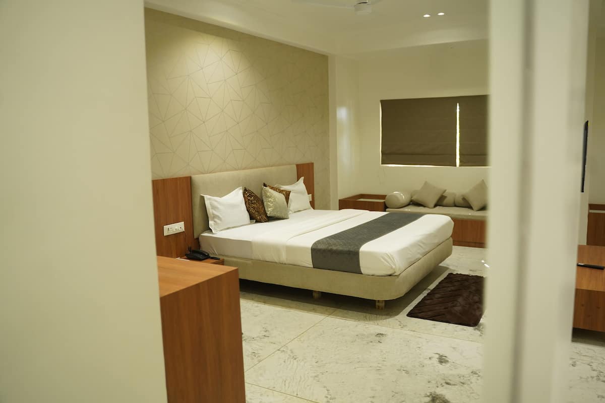 A modern bedroom with a large bed, bedside tables, and a window.