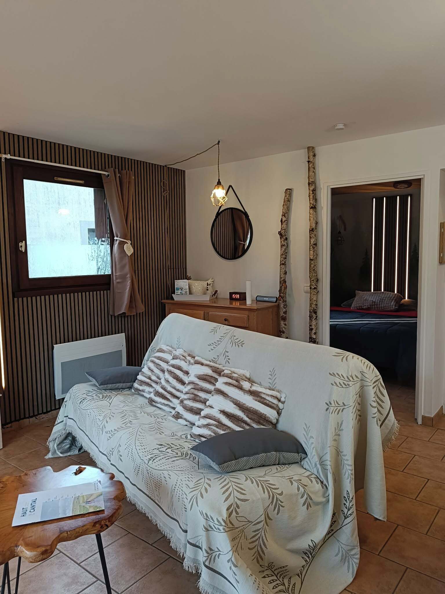 A modern bedroom with a bed, bedside table, and a window with curtains.