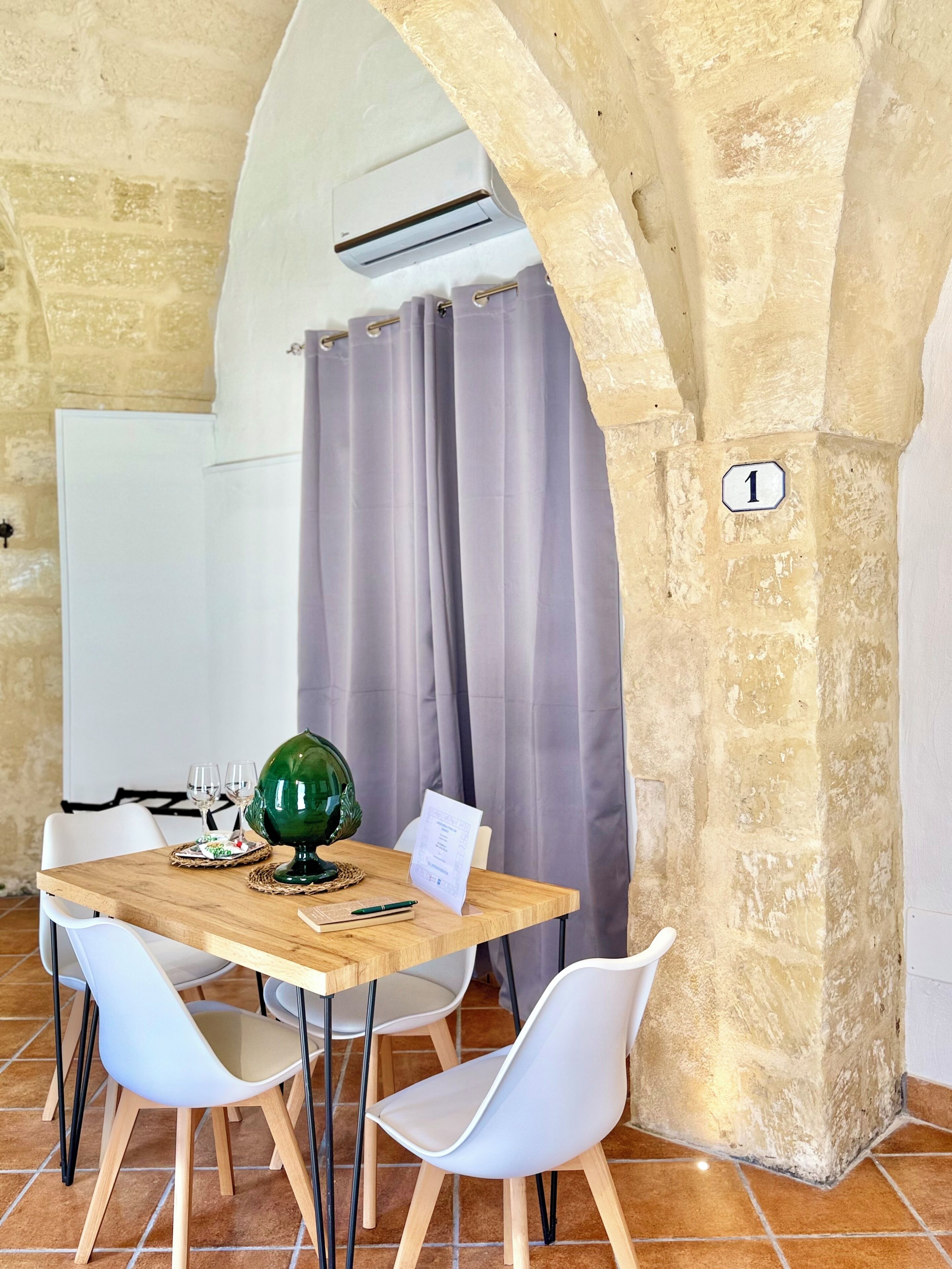 Una habitación con una mesa de madera, sillas blancas, un globo terráqueo y una pizarra blanca.