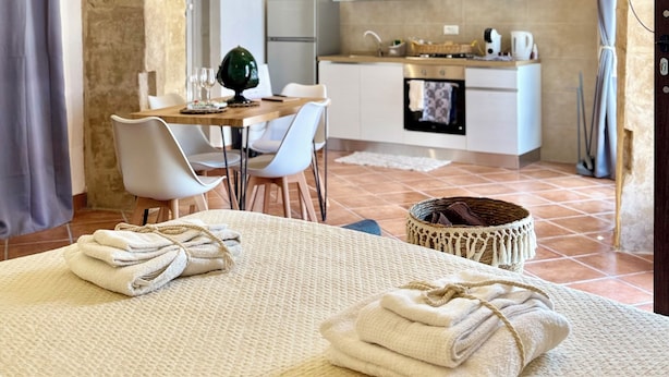 A room with a bed, a dining area, and a kitchen.