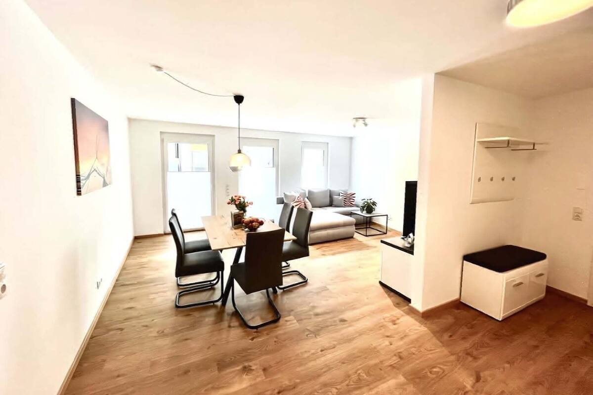 Eine moderne Wohnung mit Essbereich, Wohnzimmer und einer kleinen Küchenzeile.
