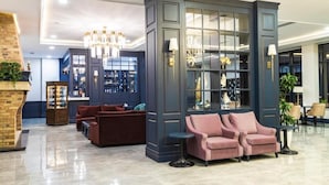A modern lobby with a dark blue reception desk, plush seating, and a chandelier. - Macara Lake Park Hotel (Quba)