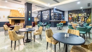 A modern hotel lobby with a fireplace, seating areas, and a bar. - Macara Lake Park Hotel (Quba)