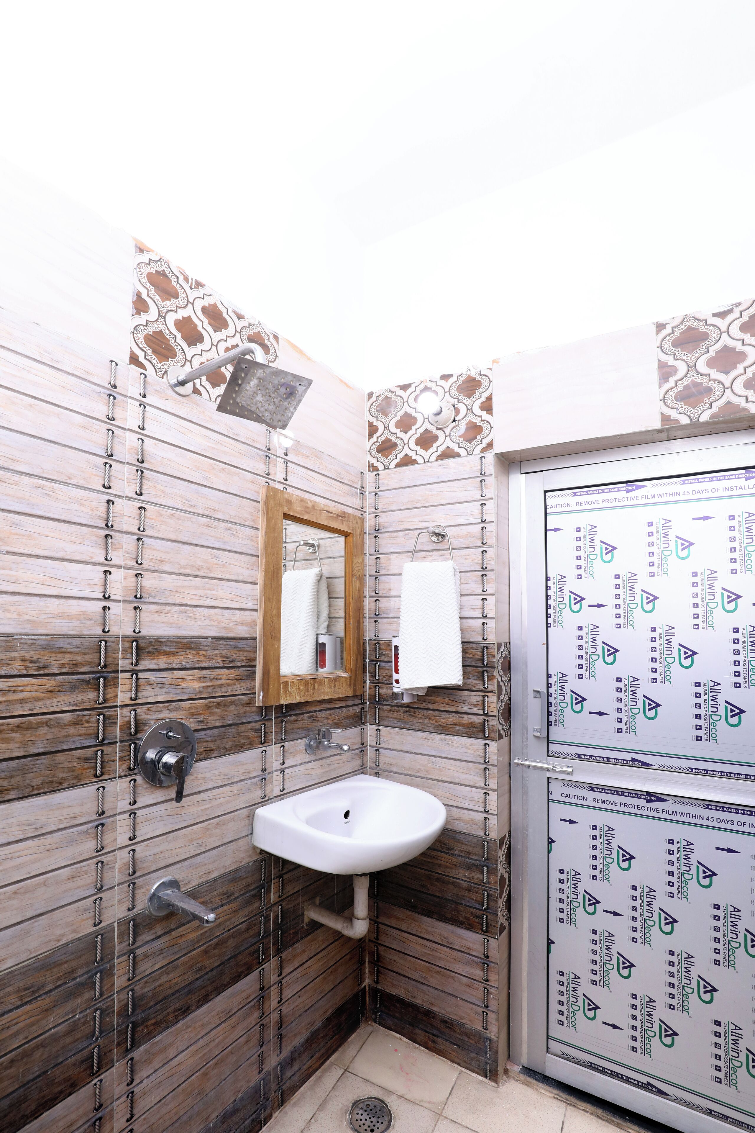A bathroom with a wooden panel wall, a white sink, and a mirror.