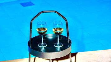 A round table with a black metal frame and two wine glasses on it.