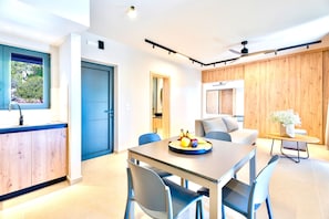 Une cuisine moderne avec un coin repas, une porte bleue et un ventilateur de plafond.
