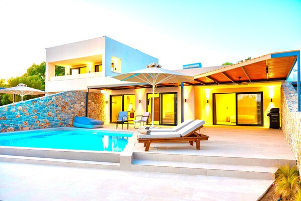 A modern house with a swimming pool, outdoor seating, and a covered patio area. - Luxurious Mediterraenan Villa 'Selene 1' with private pool and mountain and countryside views (Rhodes)