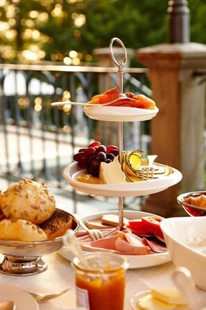 A three-tiered dessert stand with various pastries and fruits. - LA VILLA am Starnberger See (Poecking)