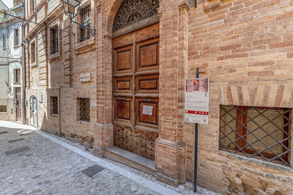 Un bâtiment historique doté d’une grande porte en bois, d’une enseigne indiquant qu’il s’agit d’un musée, et situé sur une rue pavée.