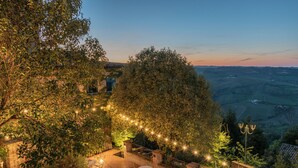 A terrace with outdoor seating, surrounded by trees and a view of the countryside. - Hotel Oviv Dimora del borgo (Acquaviva Picena)