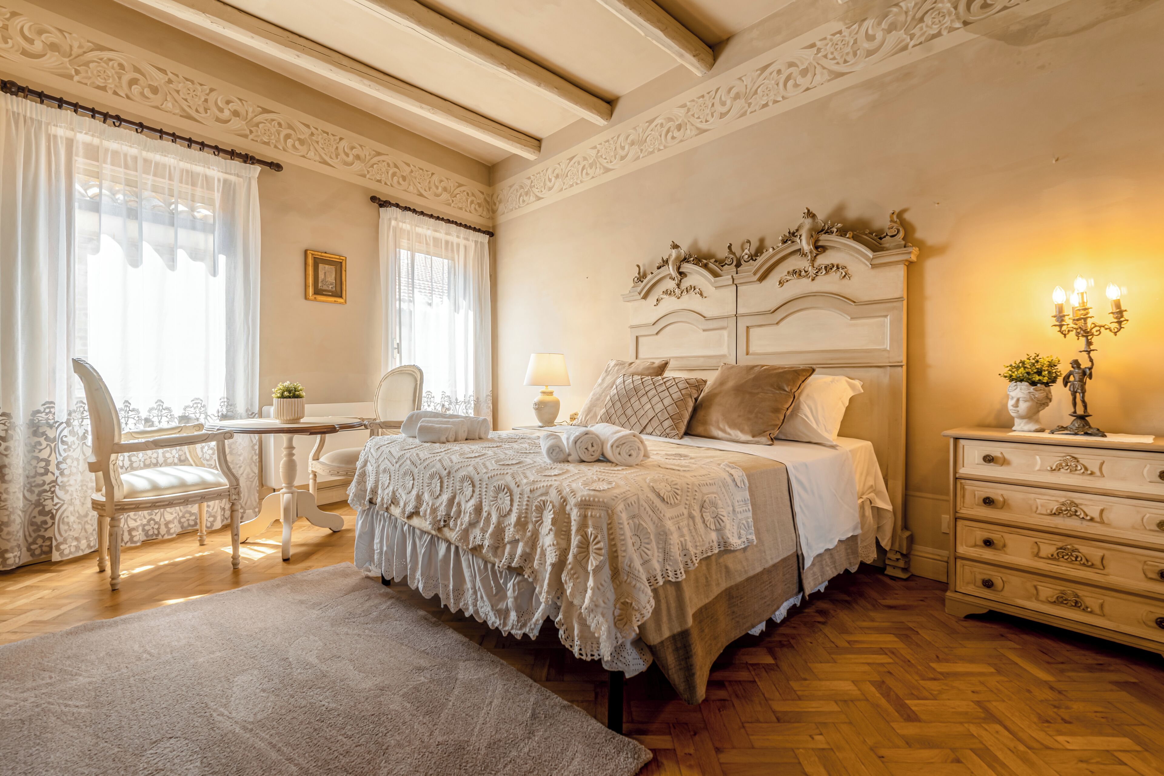 A bedroom with a bed, bedside table, chair, and a dresser.