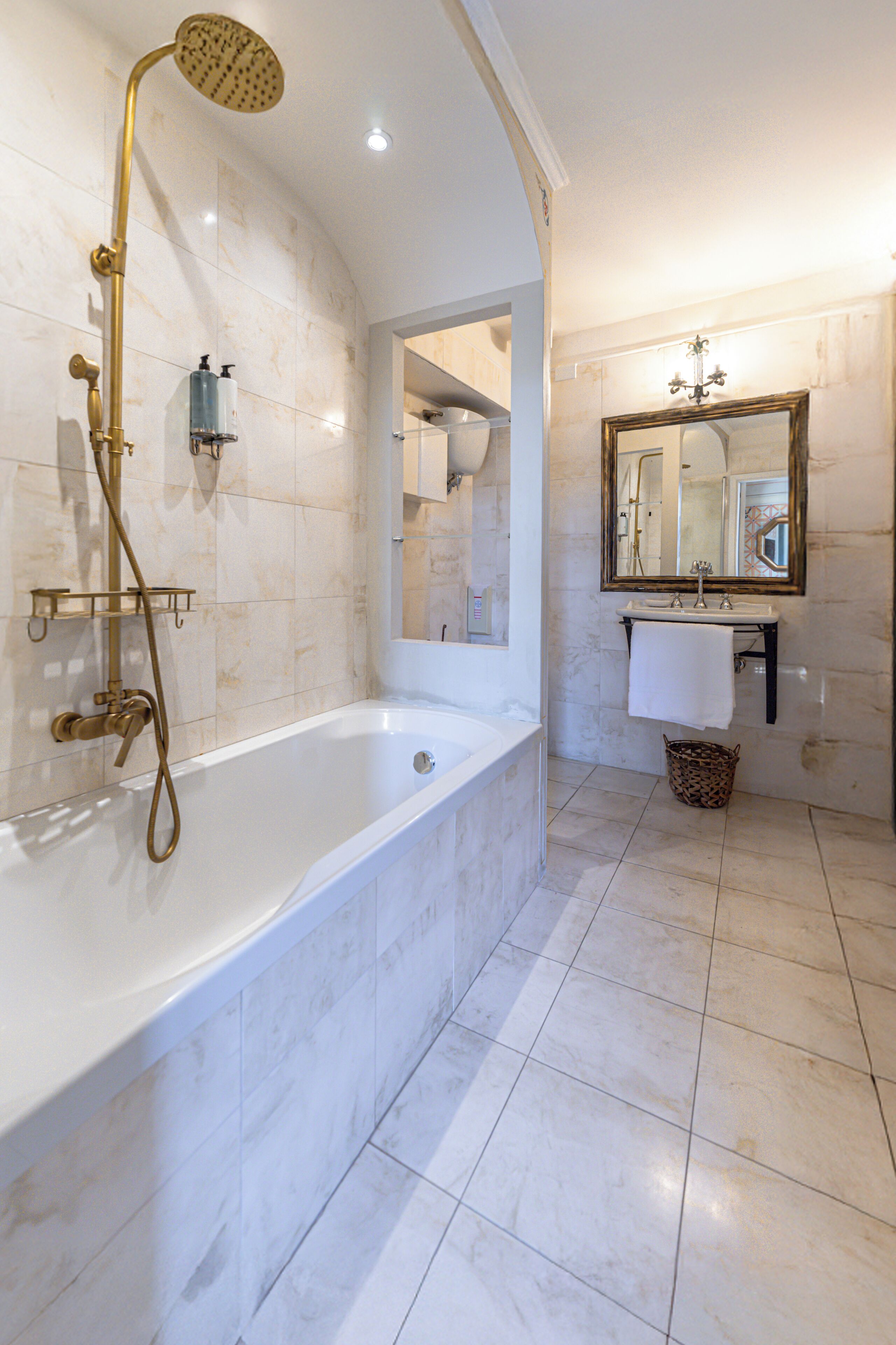 A bathroom with a bathtub, a showerhead, a sink, and a mirror.