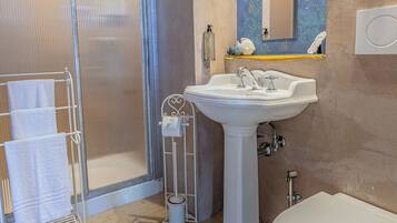 Ein Badezimmer mit Dusche, Waschbecken und Toilette.