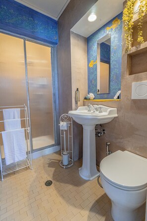 Un bagno con doccia, lavandino e WC.
