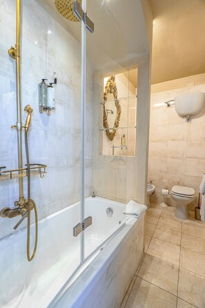 Un bagno moderno con doccia vetrata, una vasca da bagno indipendente, un lavabo con specchio e il water.
