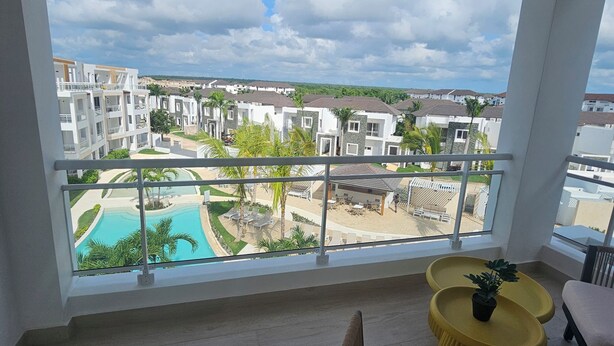 Ein Balkon mit Blick auf ein Schwimmbecken und umliegende Gebäude.