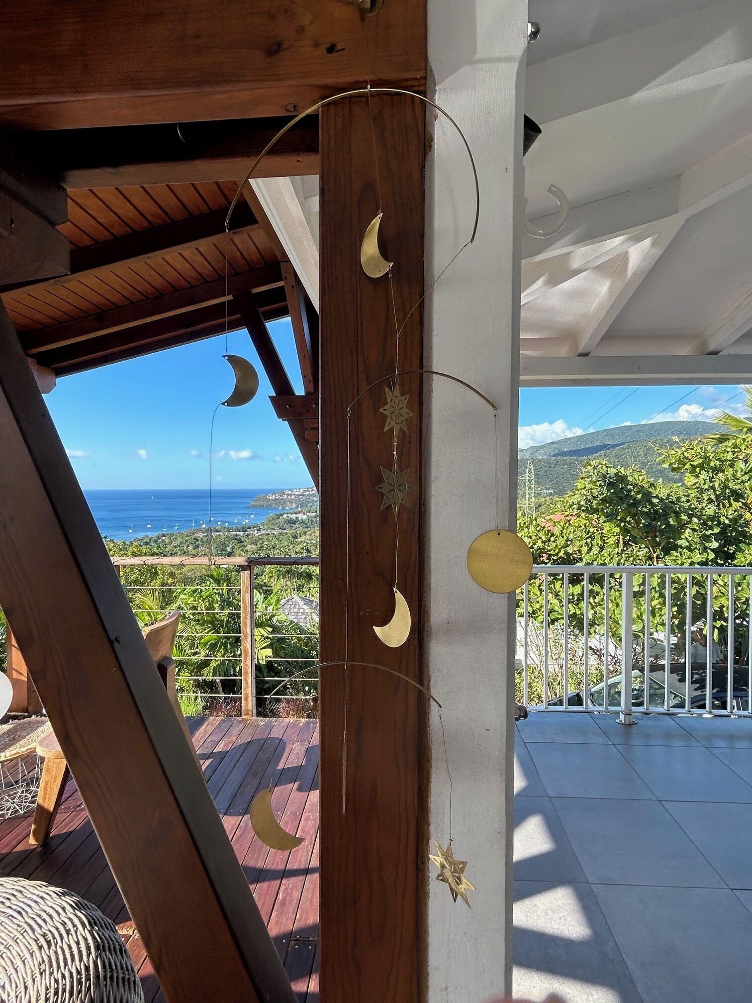 En træterrasse med udsigt over havet og bakker.