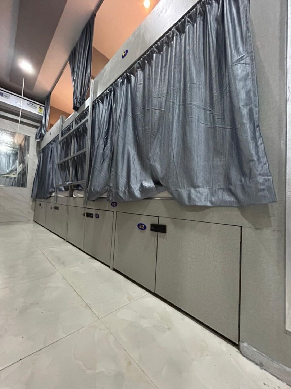 A row of lockers with a metallic finish and a tiled floor.