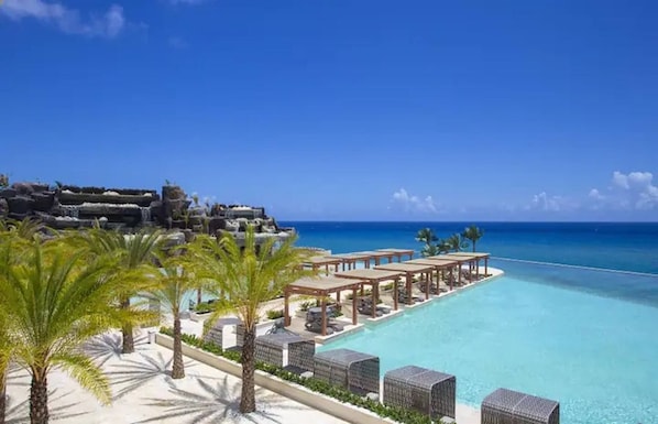 A resort with a pool, palm trees, and a view of the ocean. - Villa Ocean Dream 3BR Oasis and Guesthouse (Sosúa)
