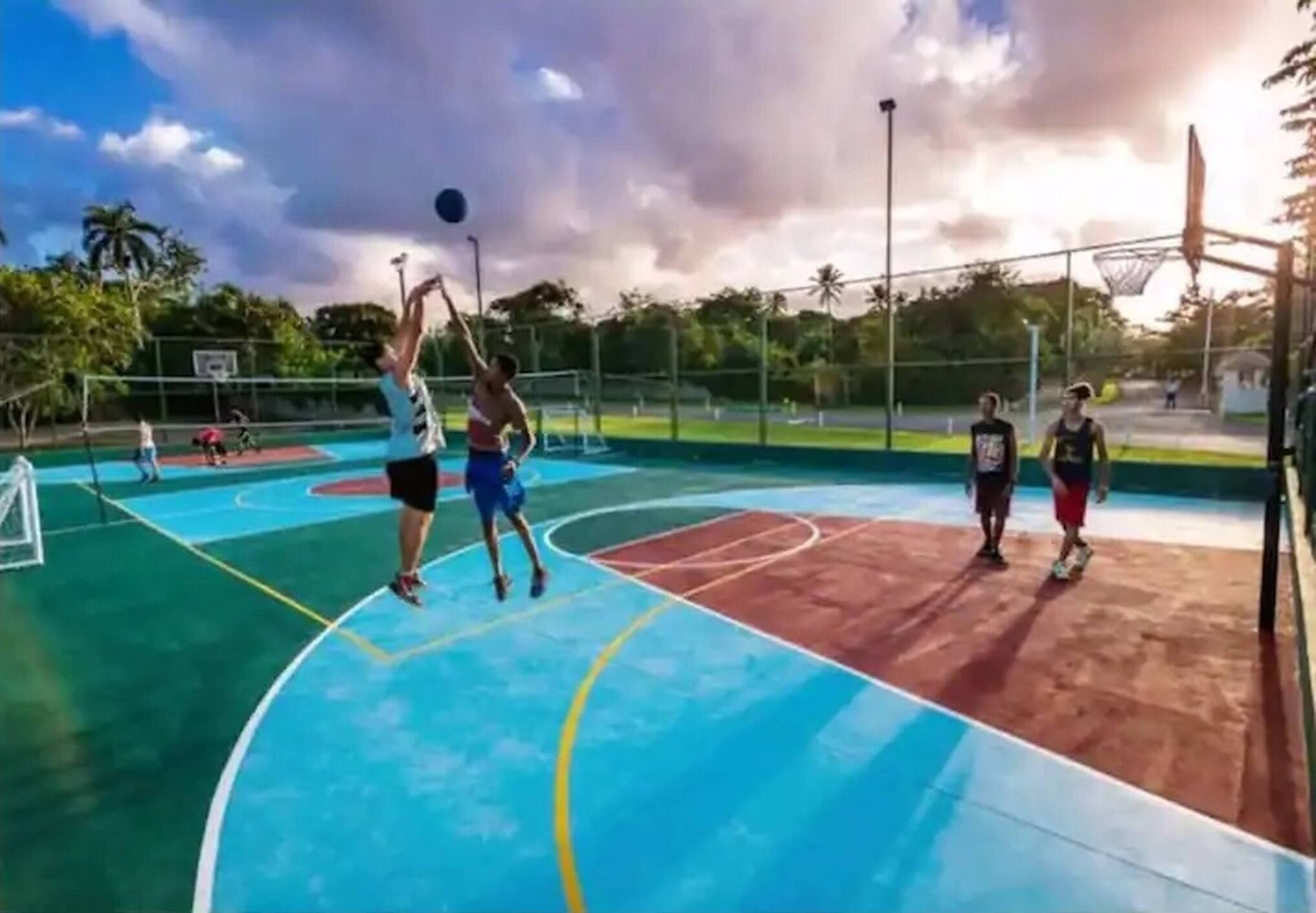 A basketball court with a net, a hoop, and a player in mid-action.