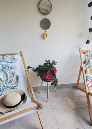A room with two wooden chairs, a small potted plant, and a wall-mounted mirror. - Kaz Ananas – Creole Cottage with Private Garden • Beach & shops within walking distance (Les Trois-Îlets)