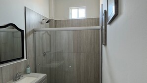 A bathroom with a shower, a sink, and a mirror. - Perfect 7-bedroom house with stunning sunsets (Rosarito)