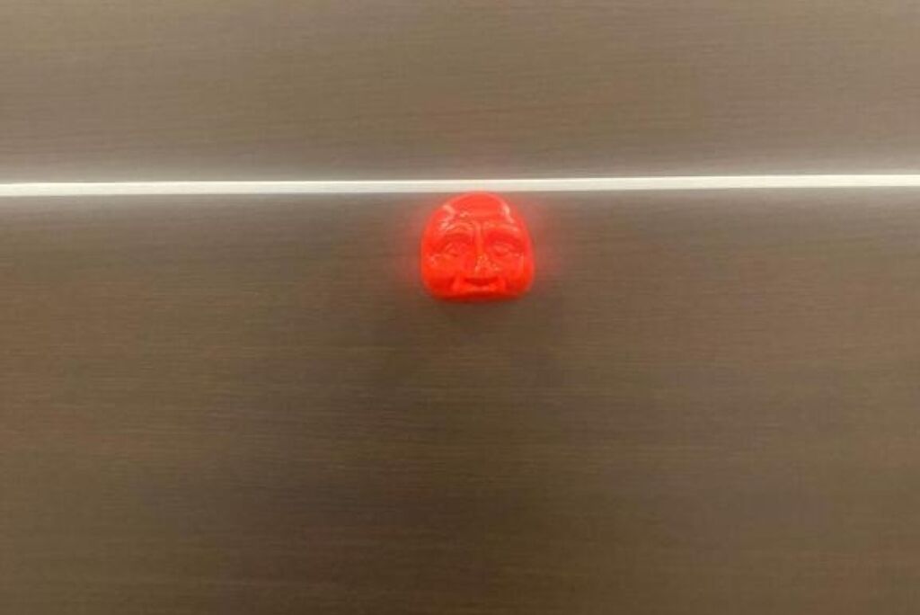 Un objeto rojo sobre una superficie metálica.