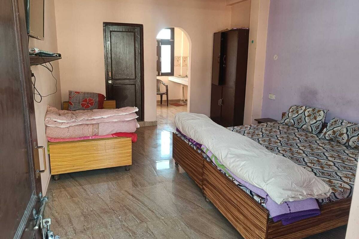 Ein Schlafzimmer mit einem Bett, einem Kleiderschrank, einem Schreibtisch und einem Sessel.
