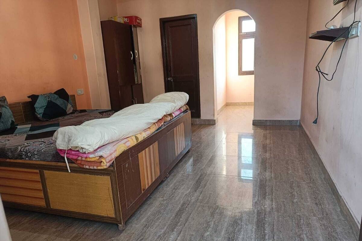 Ein Schlafzimmer mit einem Bett, einem Kleiderschrank und einer Tür zu einem anderen Raum.