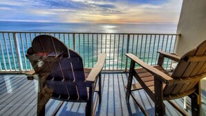 A balcony with two Adirondack chairs facing a scenic ocean view. - Emerald Escape 2007–Gulf Front–Sleeps 6 (Panama City Beach)