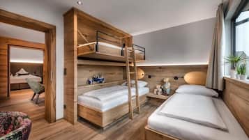 Habitación de hotel moderna con una cama nido, un escritorio, una silla y una ventana con cortinas.