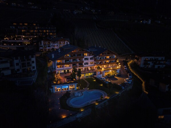 A multi-story hotel with a swimming pool, surrounded by other buildings.
