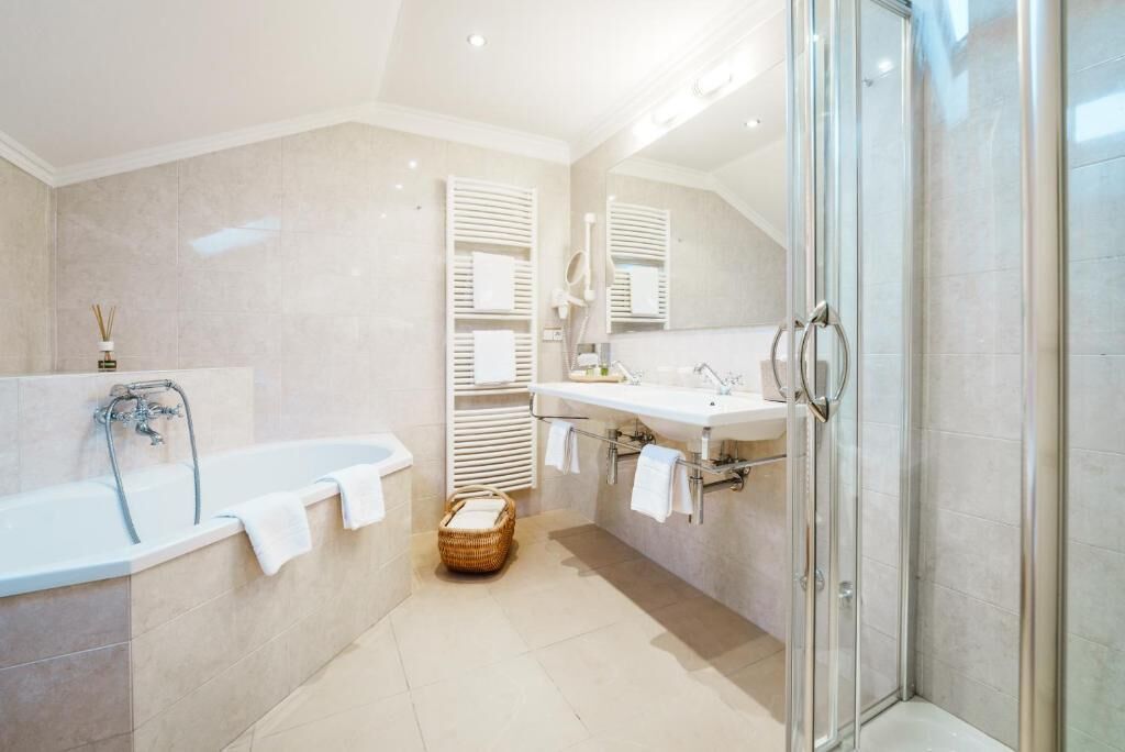 Un baño moderno con bañera, ducha y tocador con espejo.