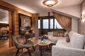 Uma sala de estar moderna com sofá, poltrona e mesa de centro com uma garrafa e flores.