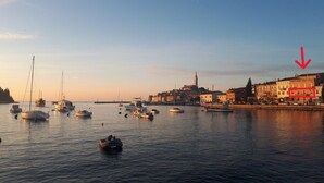 A harbor with various boats and a prominent tower in the background. - Royal Balcony al Mare (Rovinj)