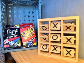 A set of board games, including Phase 10 Express and UNO Express, and wooden letter blocks spelling 'OXO' on a shelf. - Apartment T2 Port Fréjus (Fréjus)