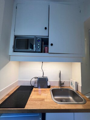 Eine kleine Küche mit Mikrowelle, Toaster und Spüle.