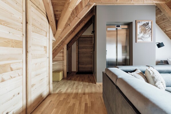 A modern interior with wooden beams, a sofa, and a framed picture on the wall. - Apres Ski Bachleda (Zakopane)